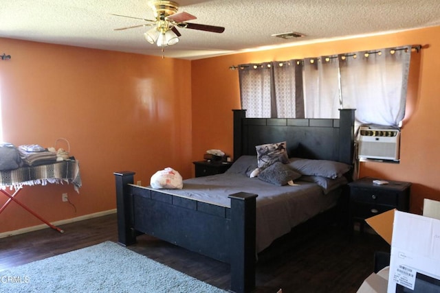 bedroom featuring dark hardwood / wood-style floors, ceiling fan, and a textured ceiling