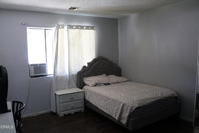 bedroom with a textured ceiling, dark hardwood / wood-style flooring, and cooling unit