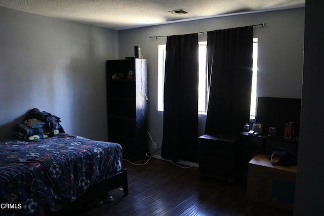 bedroom featuring hardwood / wood-style floors and a textured ceiling