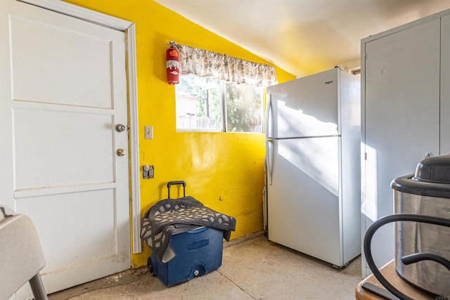 kitchen with white refrigerator and lofted ceiling