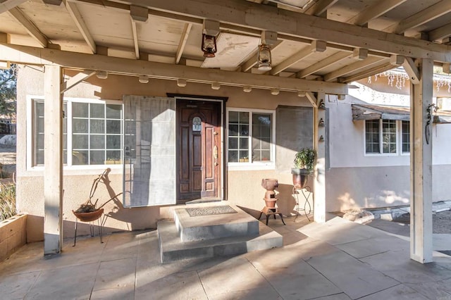 view of exterior entry with a patio