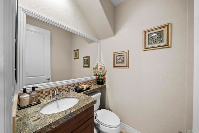 bathroom featuring backsplash, vanity, and toilet