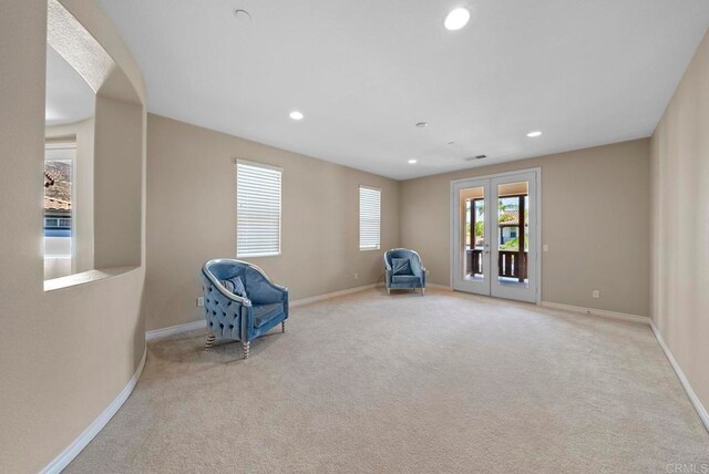 unfurnished room with light colored carpet and french doors