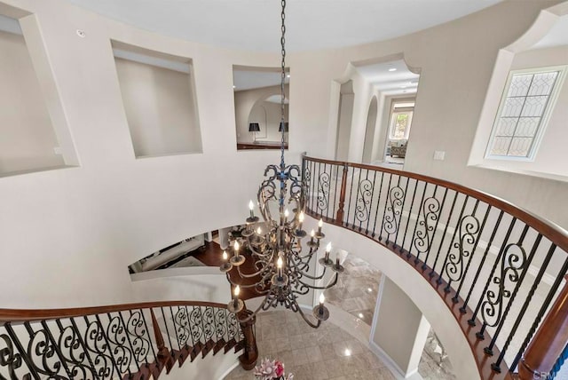 staircase featuring an inviting chandelier