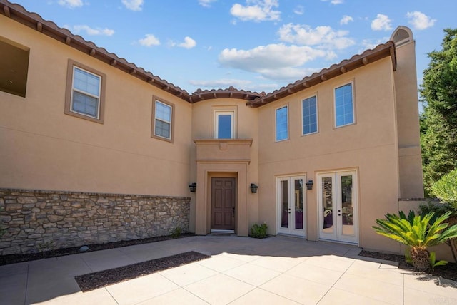 rear view of property featuring french doors and a patio area