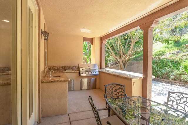 view of patio with exterior kitchen, area for grilling, and sink