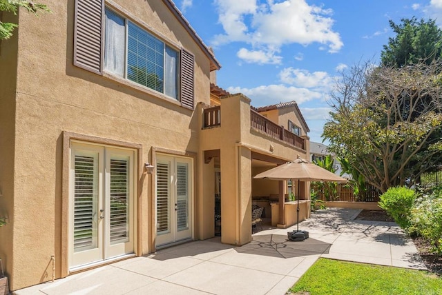 rear view of property with a patio and a balcony