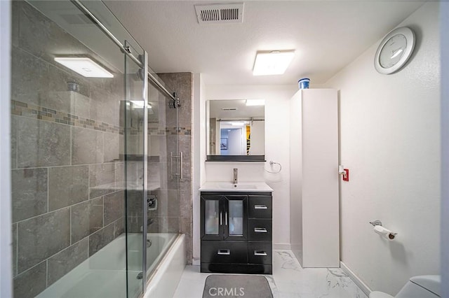 bathroom featuring bath / shower combo with glass door and vanity