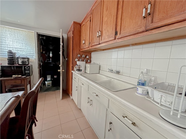 kitchen featuring sink, light tile patterned floors, and tasteful backsplash