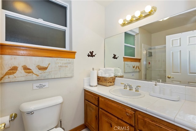 bathroom with toilet, an enclosed shower, and vanity