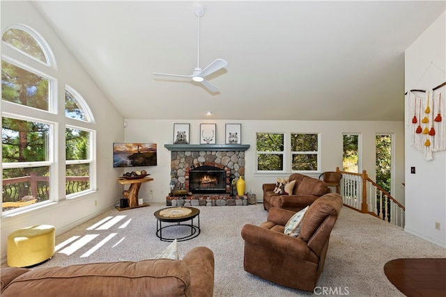 carpeted living room with ceiling fan, high vaulted ceiling, a wealth of natural light, and a fireplace