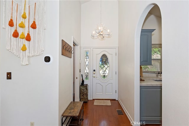 foyer featuring dark wood-type flooring and an inviting chandelier