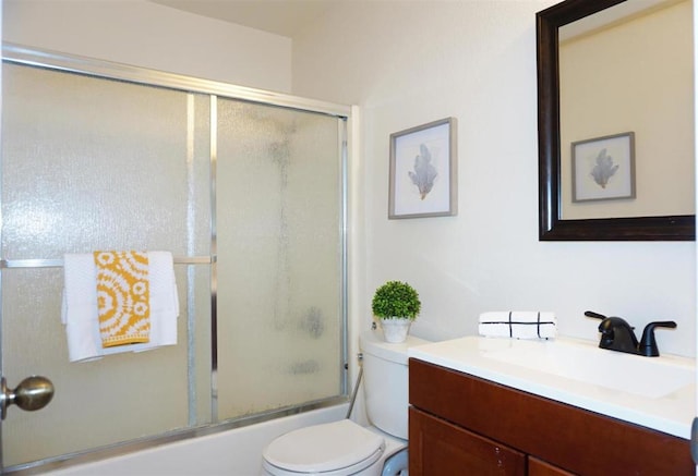 full bathroom featuring vanity, toilet, and bath / shower combo with glass door