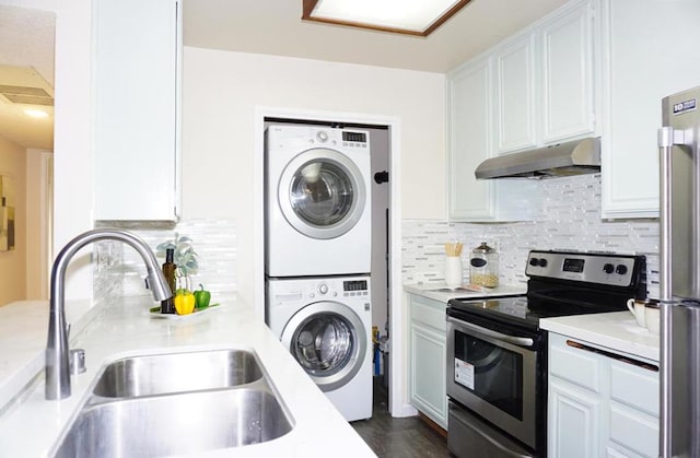 kitchen featuring white cabinets, sink, decorative backsplash, appliances with stainless steel finishes, and stacked washer / dryer