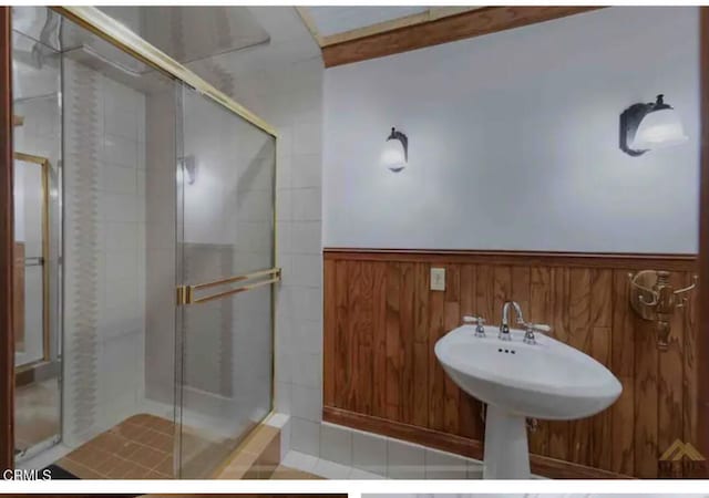 bathroom featuring wooden walls and an enclosed shower