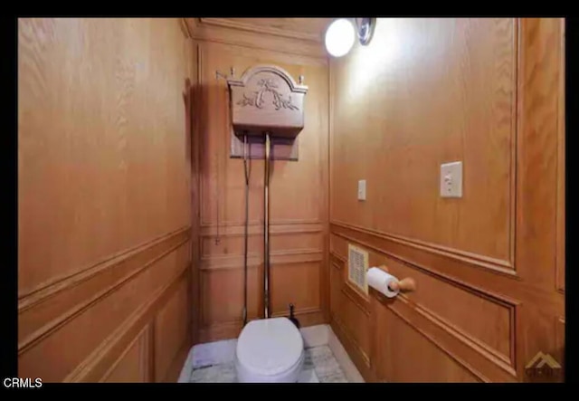 interior details featuring toilet and wooden walls