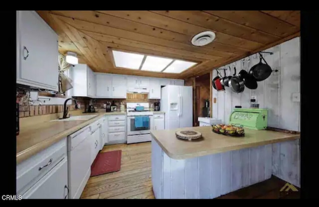 kitchen featuring kitchen peninsula, white cabinetry, light hardwood / wood-style flooring, sink, and white appliances