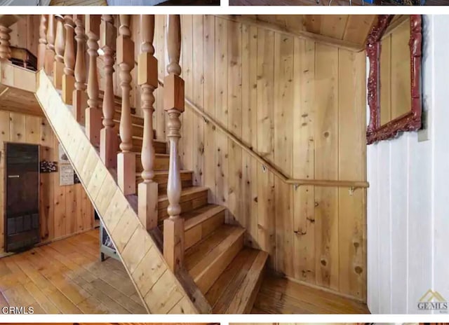 stairs featuring lofted ceiling, hardwood / wood-style floors, and wooden walls