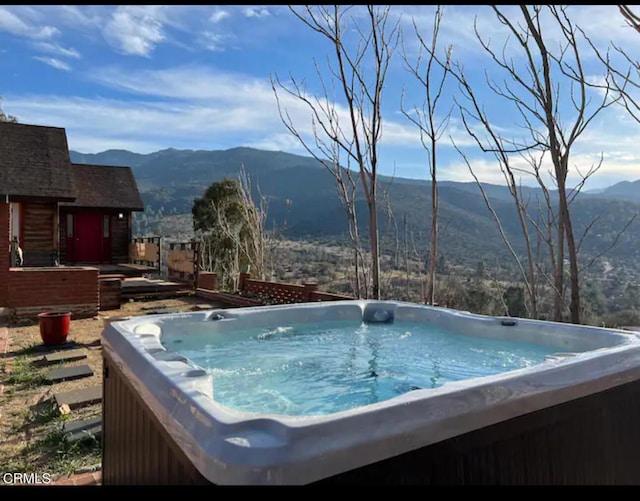 view of swimming pool featuring a hot tub and a mountain view