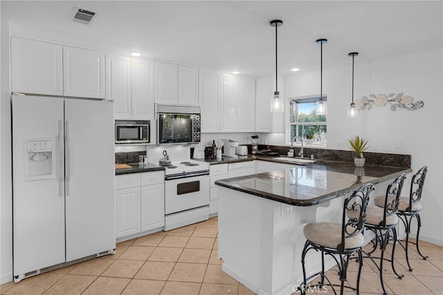 kitchen featuring pendant lighting, sink, white cabinetry, kitchen peninsula, and white appliances