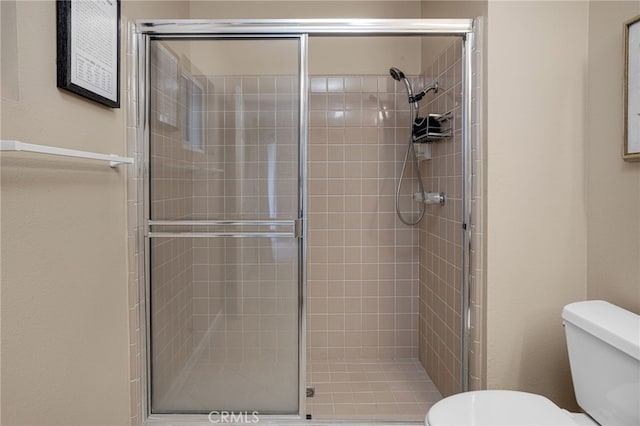 bathroom featuring walk in shower and toilet