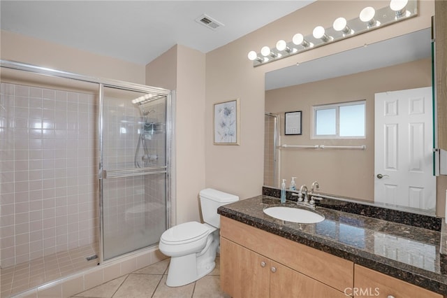 bathroom featuring tile patterned floors, a shower with door, vanity, and toilet