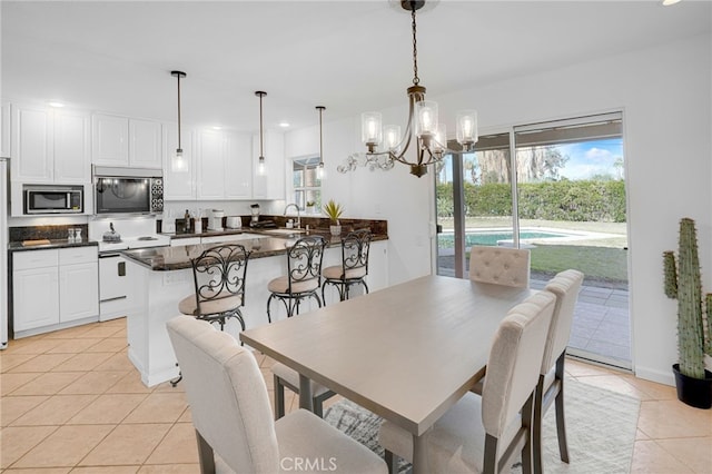 dining area featuring sink, a chandelier, and light tile patterned flooring