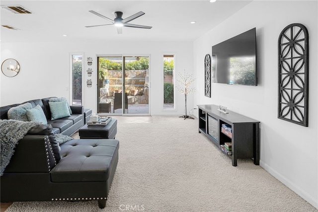 carpeted living room with ceiling fan