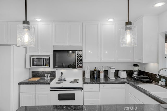 kitchen with white cabinets, white appliances, hanging light fixtures, and sink