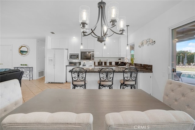 tiled dining area featuring an inviting chandelier and sink