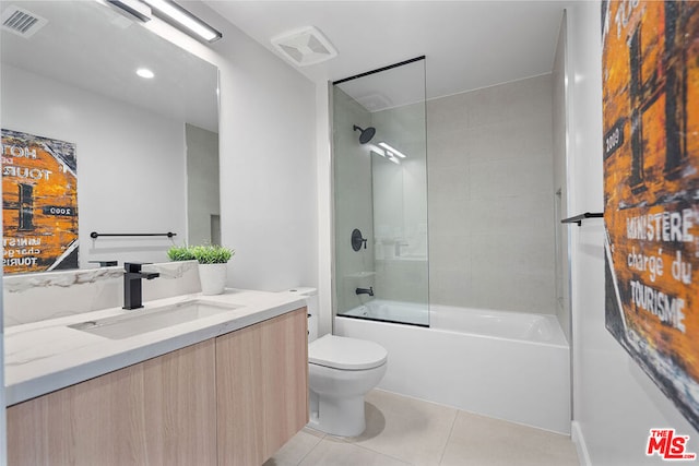 full bathroom with tiled shower / bath, vanity, tile patterned flooring, and toilet