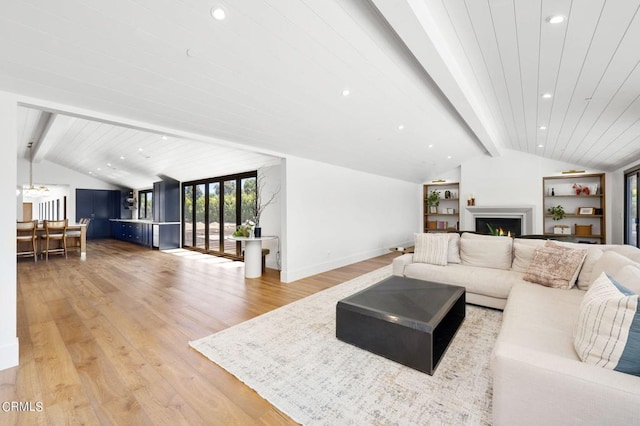 living room with lofted ceiling with beams and light hardwood / wood-style flooring