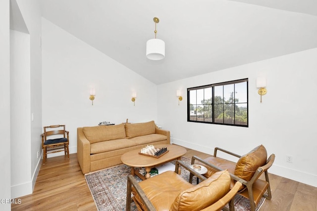 living room featuring light wood-type flooring and vaulted ceiling