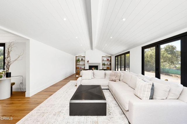 living room with lofted ceiling with beams and light hardwood / wood-style floors