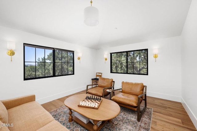 living room featuring vaulted ceiling, plenty of natural light, and light hardwood / wood-style floors