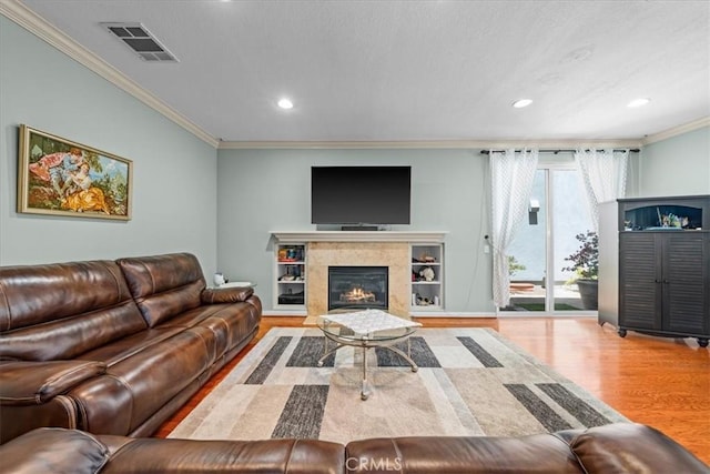 living room featuring ornamental molding, a fireplace, and hardwood / wood-style floors