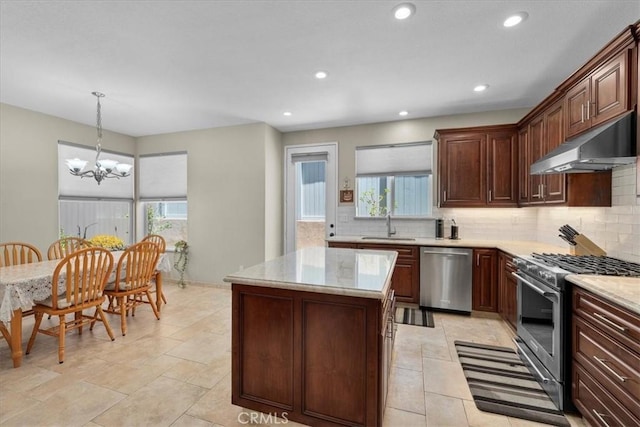 kitchen featuring stainless steel appliances, a kitchen island, backsplash, a chandelier, and pendant lighting