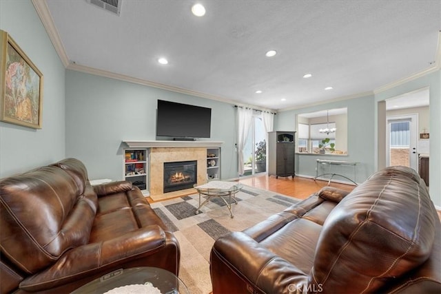 living room with ornamental molding, a fireplace, and a notable chandelier