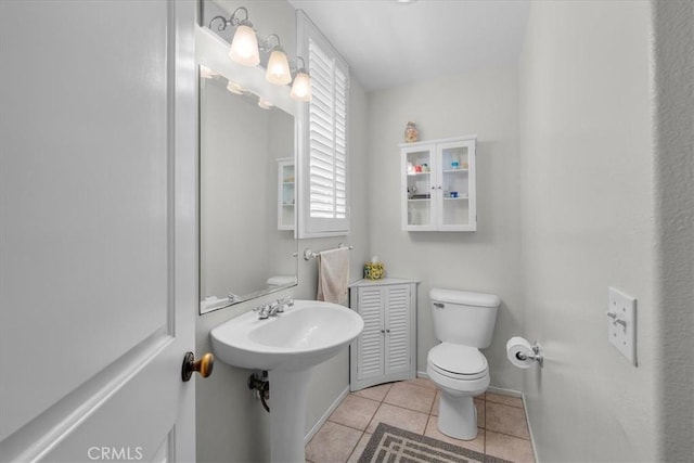 bathroom featuring toilet, sink, and tile patterned floors