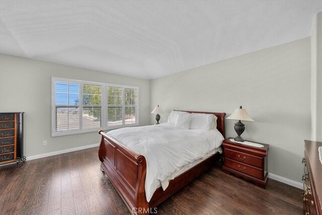 bedroom with dark hardwood / wood-style flooring