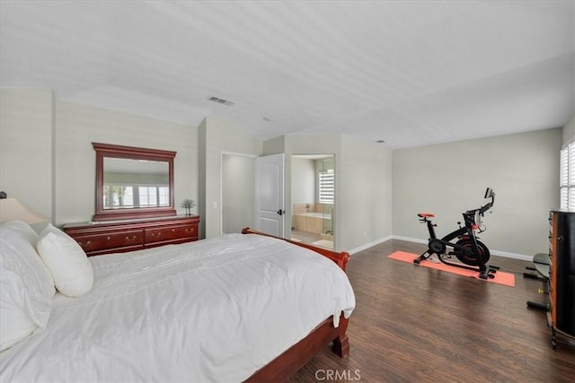 bedroom with dark wood-type flooring, ensuite bathroom, and multiple windows