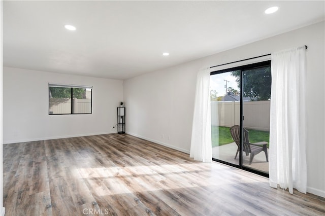 spare room with a wealth of natural light and light hardwood / wood-style flooring