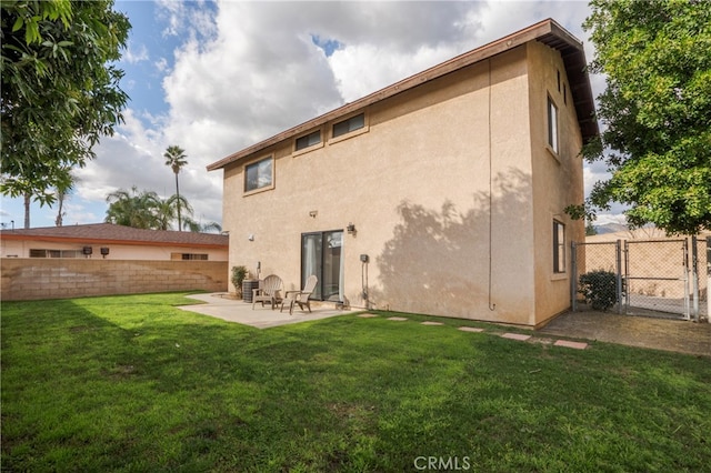 rear view of property with a patio and a lawn