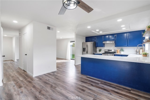 kitchen with dark hardwood / wood-style floors, stainless steel appliances, sink, and blue cabinets