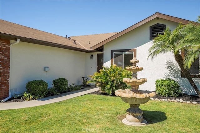 entrance to property featuring a lawn