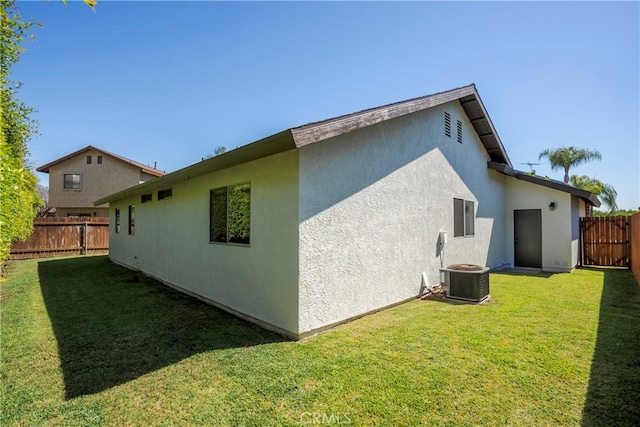 rear view of property with a lawn and cooling unit