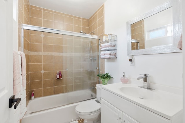 full bathroom featuring vanity, toilet, and bath / shower combo with glass door