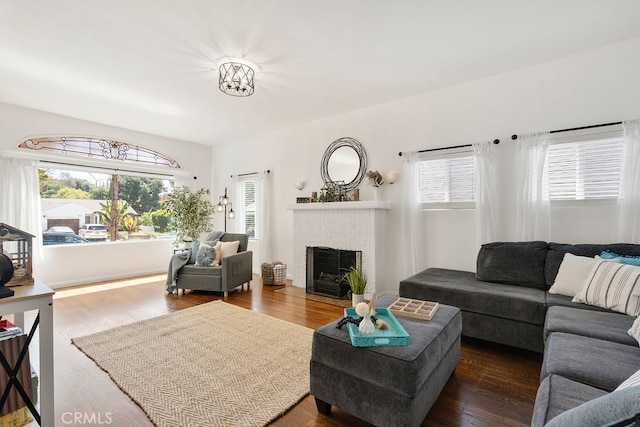 living room with a fireplace and dark wood-type flooring