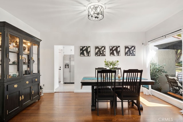 dining space with dark wood-type flooring and a notable chandelier