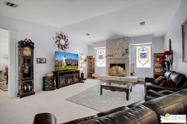 living room with carpet, a large fireplace, vaulted ceiling, and a healthy amount of sunlight